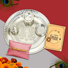 Charming gift arrangement with designer Rakhi, shining thali, roli-chawal, and vibrant greeting card.