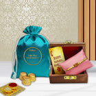 Raksha Bandhan gift set combining a stylish wooden Rakhi box with chocolates, ritual powders, and festive greeting card.